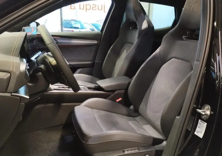 Vue intérieure côté conducteur du CUPRA Formentor noir métal, mettant en valeur les sièges baquets en suédine avec surpiqûres cuivrées.