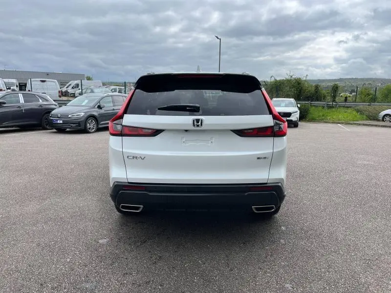 Vue arrière d'un Honda CR-V blanc platine nacré 2024 avec feux arrière LED et double sortie d'échappement chromée.