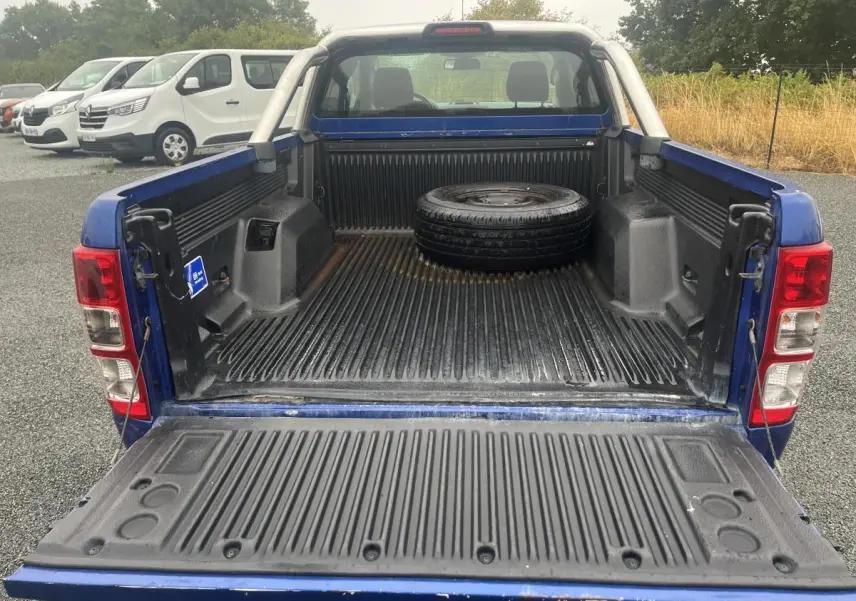 Vue arrière du Ford Ranger bleu 2019 avec benne ouverte et roue de secours posée à l'intérieur.