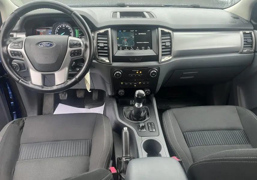 Intérieur avant du Ford Ranger bleu 2019, tableau de bord avec écran tactile et volant cuir multifonctions.