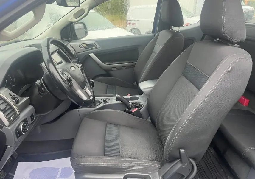 Intérieur avant du Ford Ranger bleu 2019, vue côté conducteur montrant sièges tissu gris et volant multifonction.