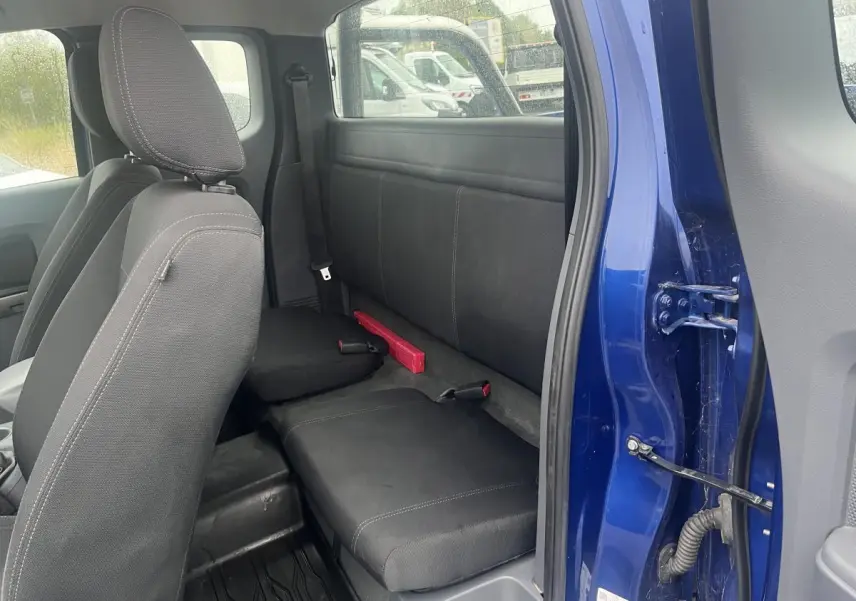 Vue intérieure côté droit du Ford Ranger bleu 2019, montrant les sièges arrière en tissu noir et la portière ouverte.