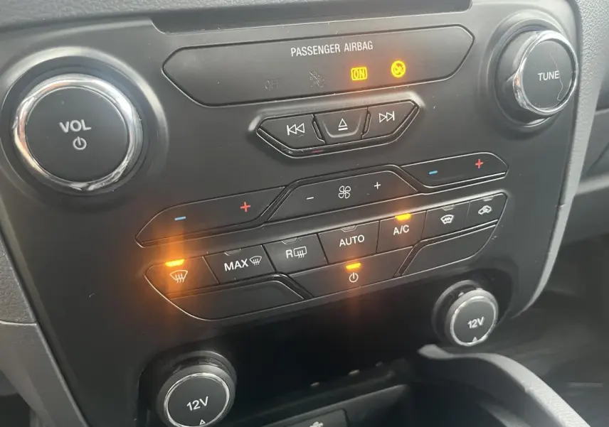 Détail du tableau de bord noir du Ford Ranger 2019, avec commandes climatisation et boutons lumineux allumés.