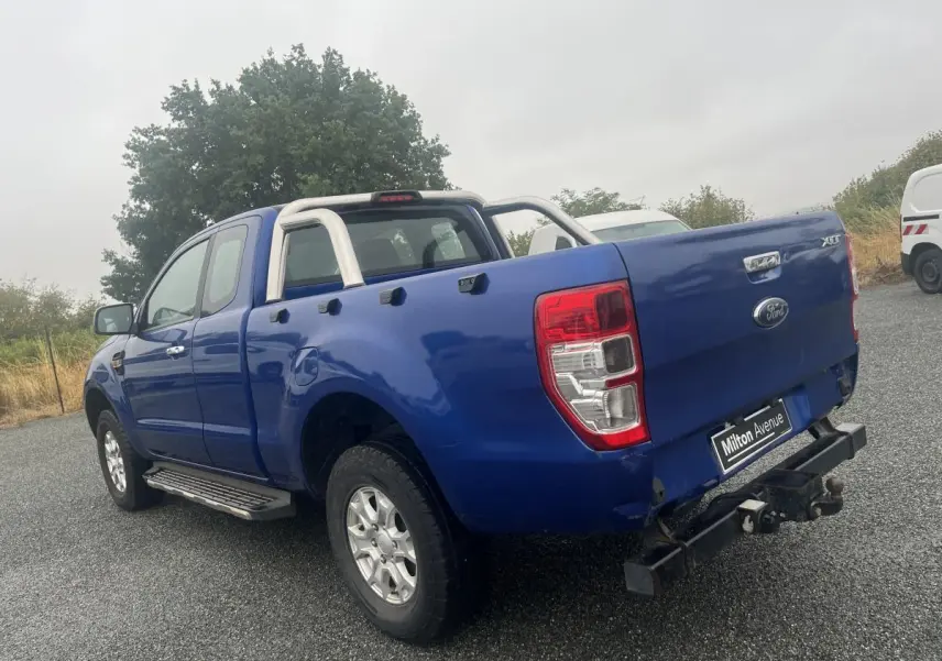 Ford Ranger 2.2 TDCi bleu en 3/4 arrière droit avec crochet d'attelage et barres de protection chromées