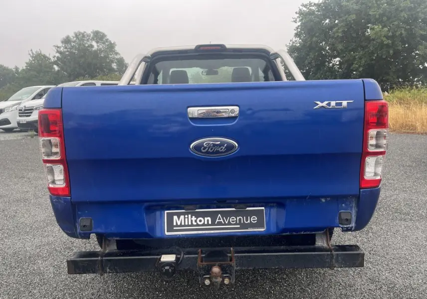 Vue arrière du Ford Ranger bleu avec crochet d'attelage et badge XLT sur ridelle arrière.
