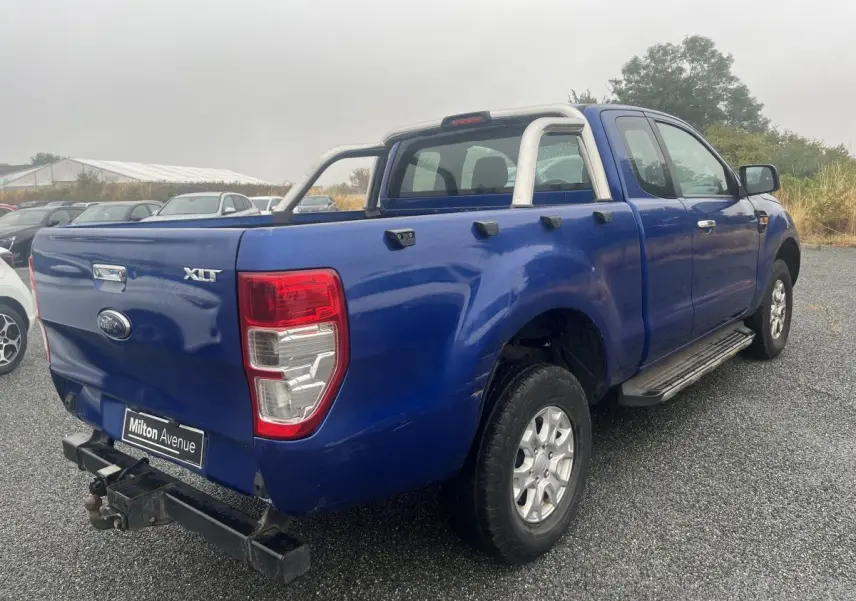 Ford Ranger XLT bleu en 3/4 arrière droit avec crochet d'attelage et barres de protection sur plateau