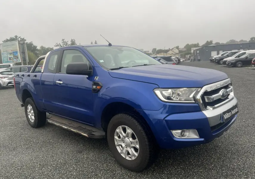 Ford Ranger 2.2 TDCi bleu métallisé en 3/4 avant droit avec calandre chromée et marchepieds latéraux.