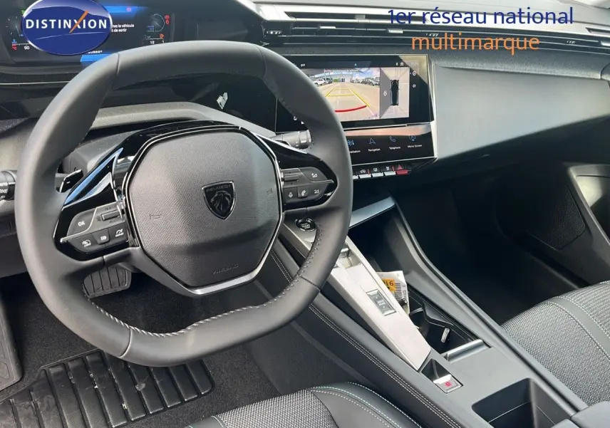 Intérieur moderne de la Peugeot 308 2024, vue du poste de conduite avec volant compact et écran tactile central.