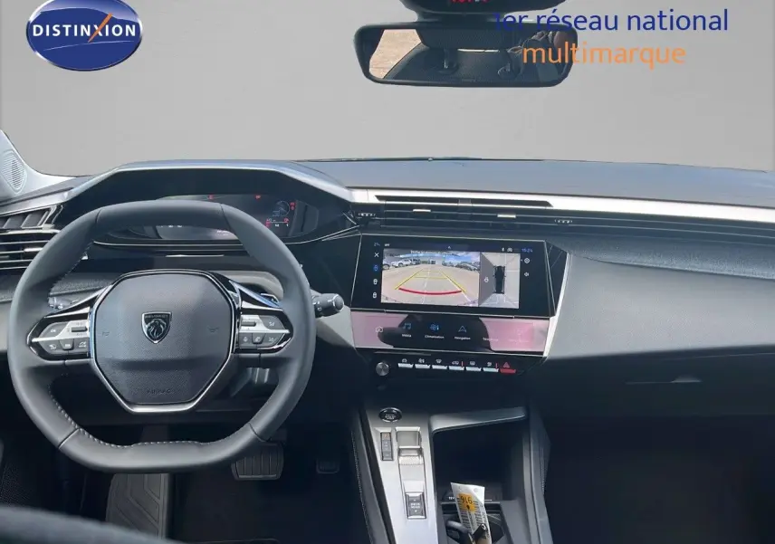 Vue intérieure du tableau de bord de la Peugeot 308 hybride 2024, avec écran tactile affichant la caméra de recul.