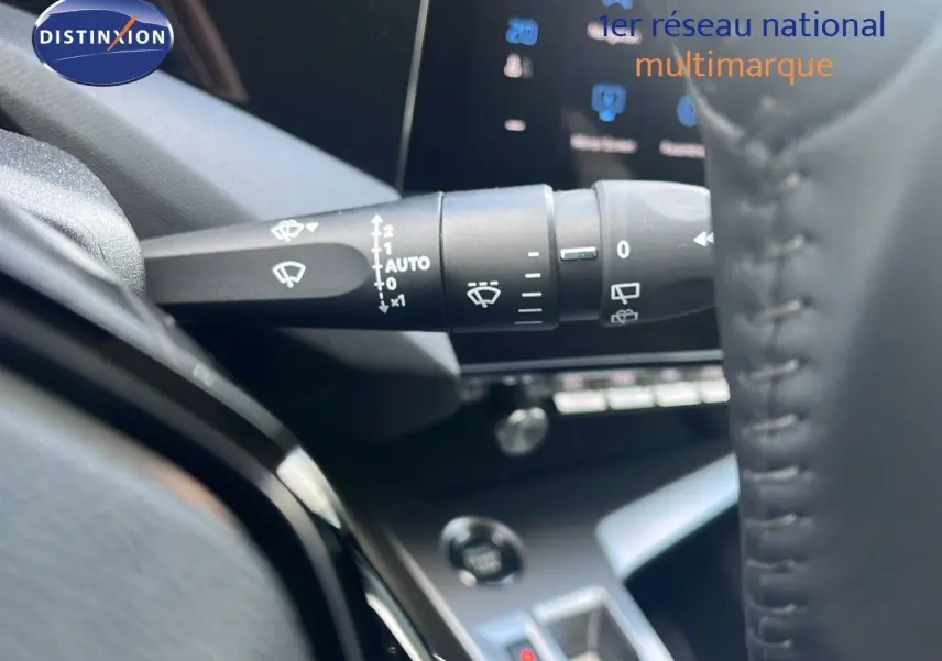 Gros plan sur la commande d'essuie-glace à gauche du volant dans l'habitacle d'une Peugeot 308 1.2 Hybrid 2024.