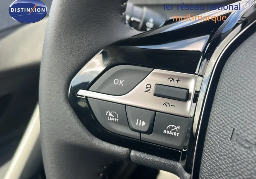 Gros plan sur les commandes au volant noir brillant de la Peugeot 308 1.2 Hybrid 136ch Allure 2024.