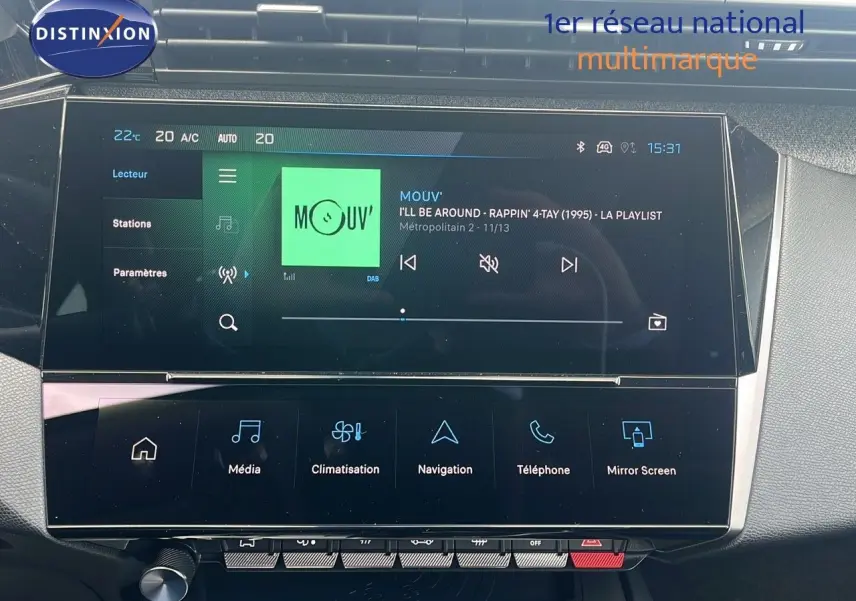 Écran tactile central de la Peugeot 308 hybride 2024 affichant la radio et les options multimédia dans un intérieur moderne.
