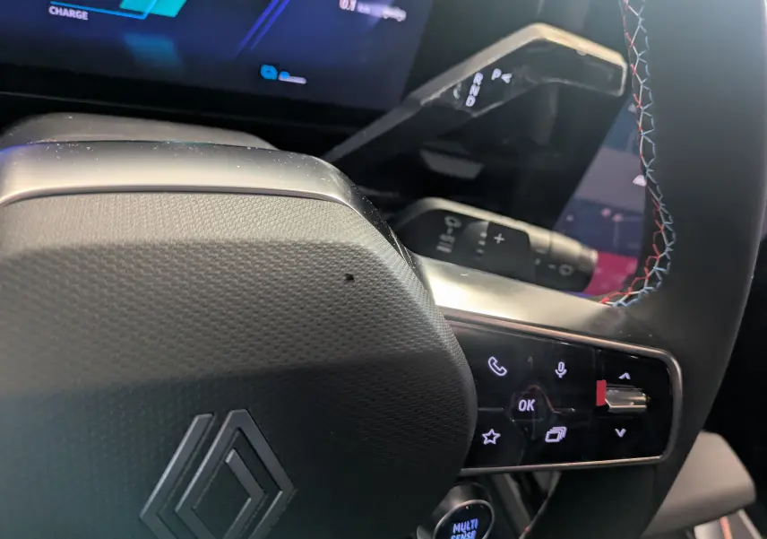 Gros plan sur le volant du Renault Austral Ph.2 E-TECH 200 Esprit Alpine, avec surpiqûres tricolores et commandes intégrées.