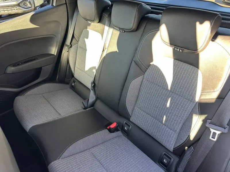 Vue intérieure sur les sièges arrière gris et noirs de la Renault Clio 1.6 E-Tech 145ch full hybrid Techno, 2025.