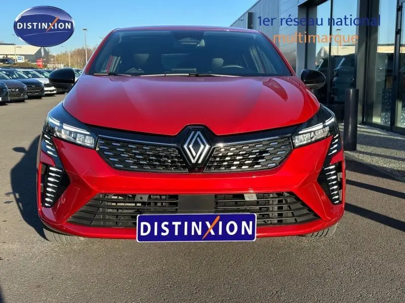 Vue frontale d'une Renault Clio 1.6 E-Tech 145ch rouge flamme avec calandre noire et feux LED distinctifs.