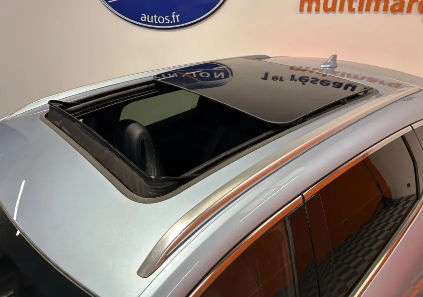 Vue en plongée du toit ouvrant ouvert d'un BYD SEAL U gris TIAN QING METAL avec barres de toit argentées.