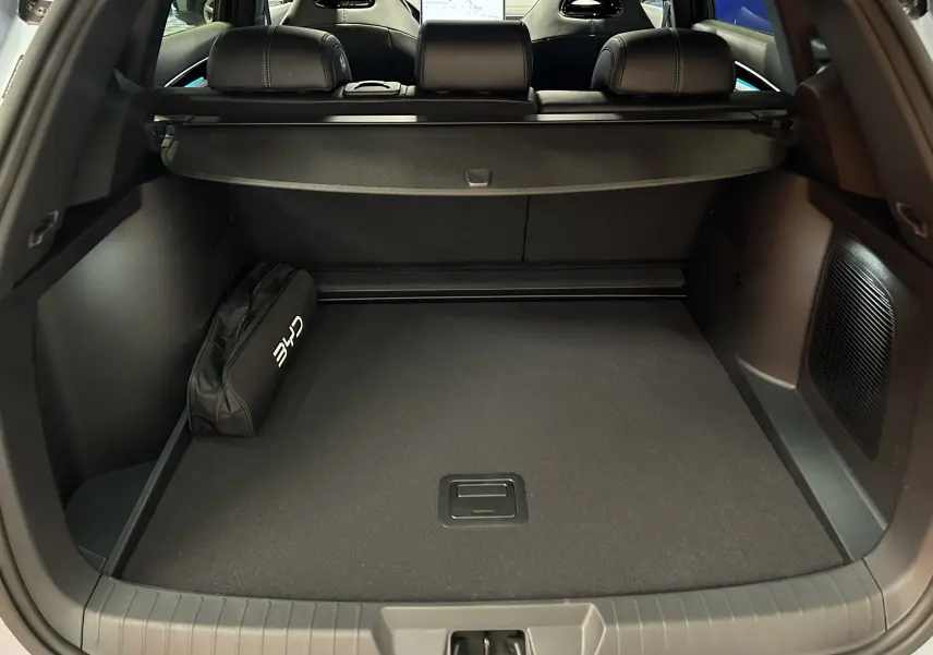 Coffre ouvert du BYD SEAL U 2025 en TIAN QING METAL, vue arrière montrant l’espace de chargement et un sac noir.