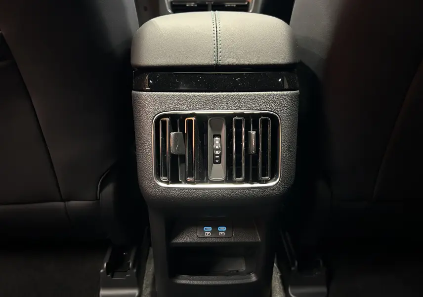 Vue rapprochée des aérateurs arrière et ports USB bleus sur console centrale noire du BYD SEAL U 2025.