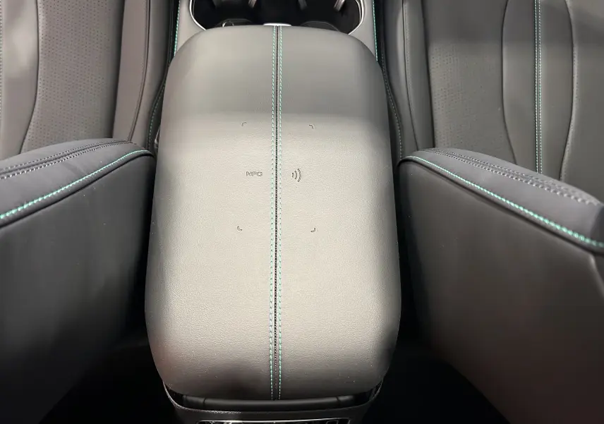 Vue rapprochée de l'accoudoir central en cuir noir avec surpiqûres bleu clair dans l'habitacle du BYD SEAL U.