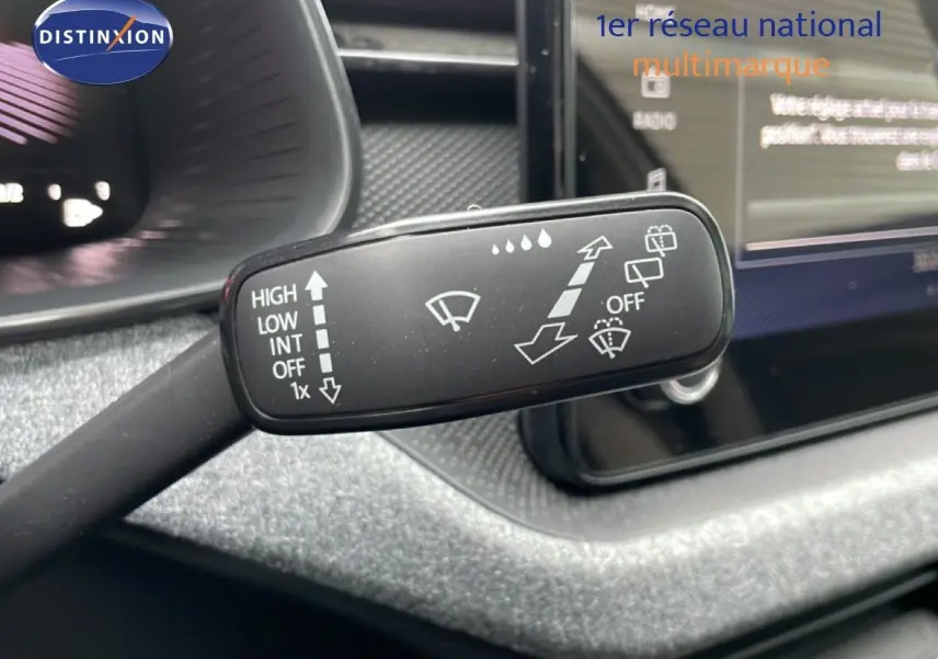 Gros plan sur la commande d’essuie-glace du Skoda Kamiq 2025, intérieur gris avec écran tactile en arrière-plan.
