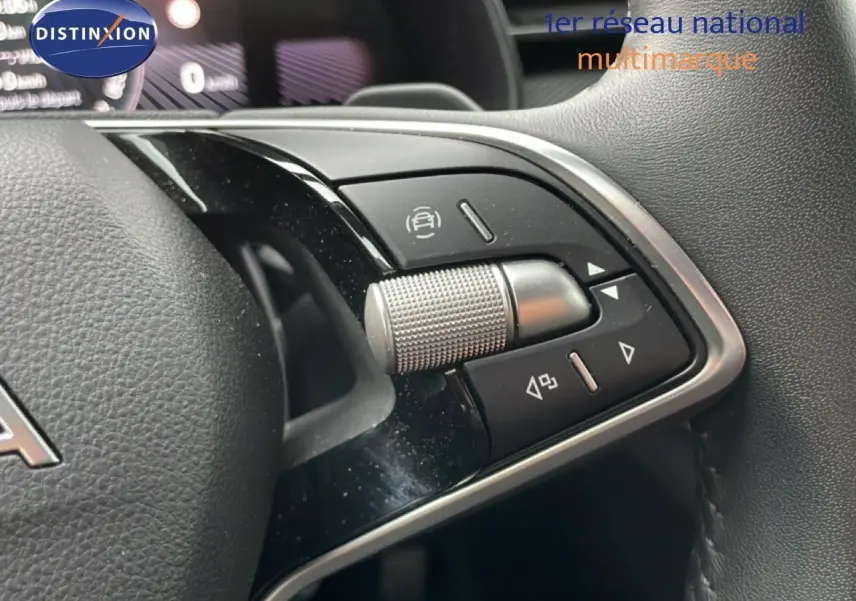 Gros plan sur les commandes multifonctions du volant du Skoda Kamiq blanc glacier, avec molette et boutons noirs.