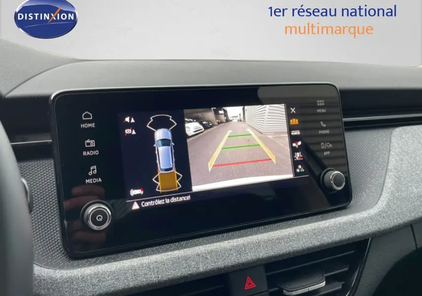Écran tactile intérieur montrant la caméra de recul du Skoda Kamiq blanc glacier, vue de face du tableau de bord.