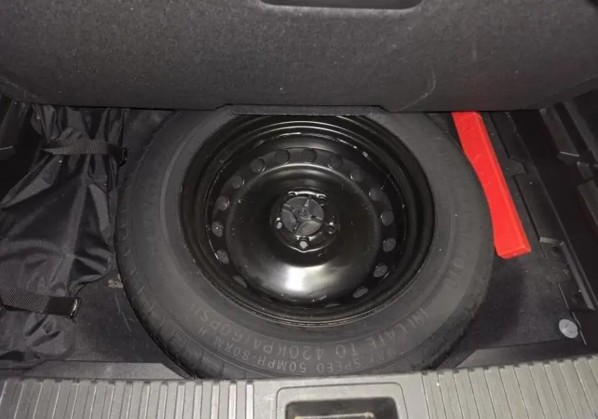 Vue rapprochée de la roue de secours galette noire dans le coffre du Renault Austral 2024 gris.