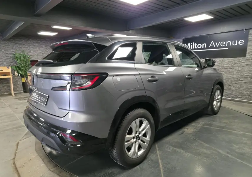 Vue 3/4 arrière droite du Renault Austral gris schiste avec feux LED et jantes alliage en intérieur showroom.