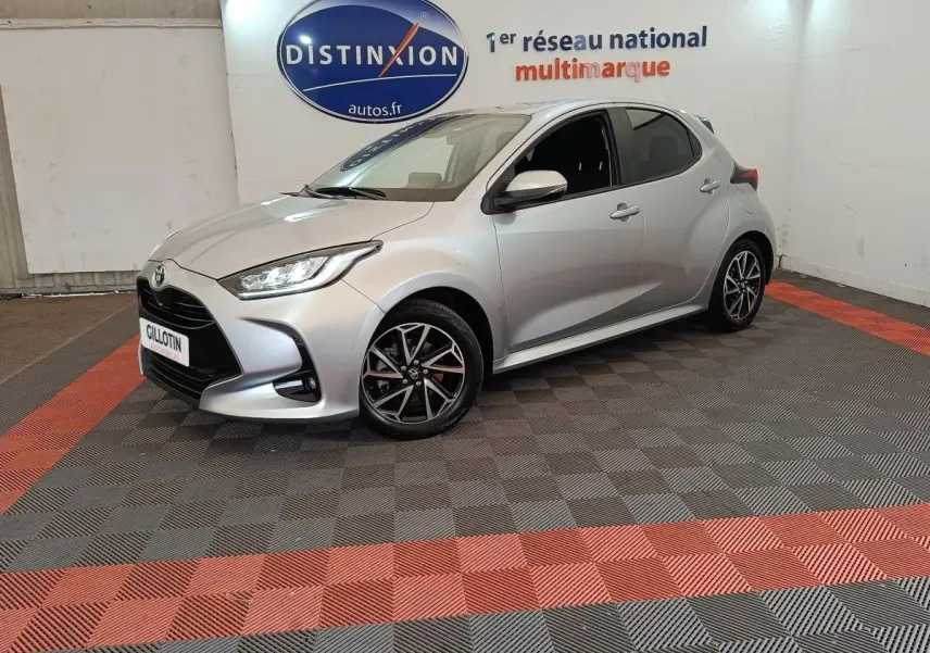 Toyota Yaris Hybride 116h gris clair vue 3/4 avant droit avec jantes alliage et phares LED ellipsoïdaux.
