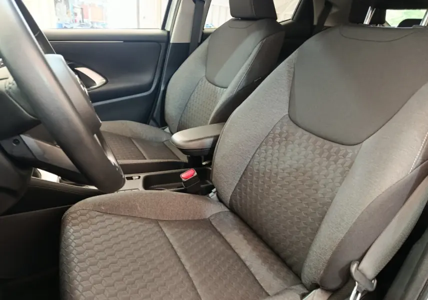 Vue intérieure rapprochée sur les sièges avant gris de la Toyota Yaris Hybride 116h Design 2023, avec volant partiellement visible.