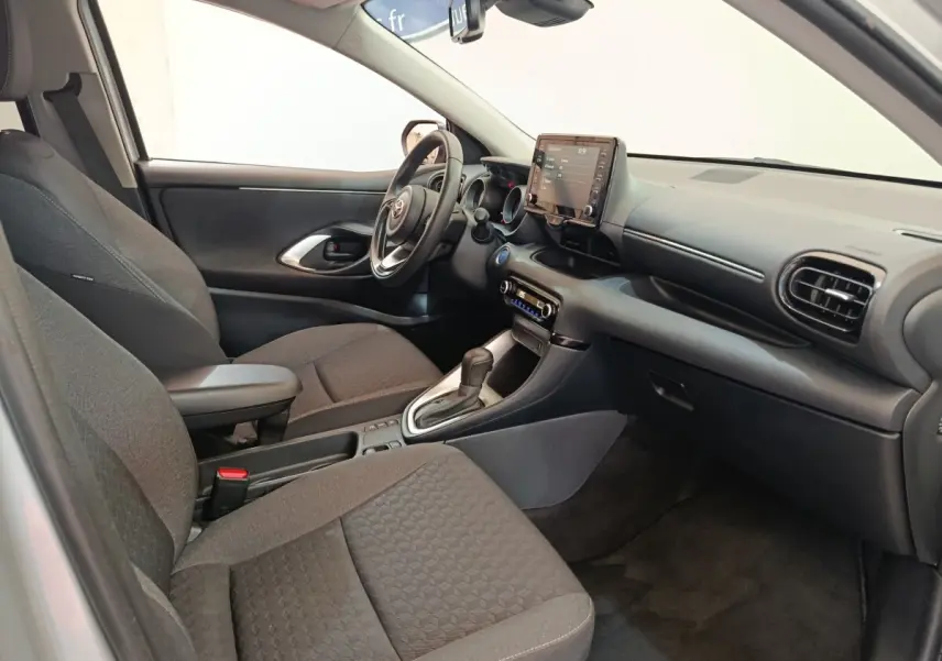 Intérieur avant droit de la Toyota Yaris Hybride 116h 2023 avec sièges gris et écran tactile central.