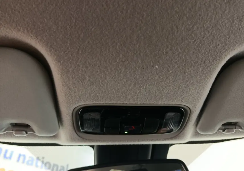 Vue intérieure du plafonnier et rétroviseur central de la Toyota Yaris hybride gris clair 2023.