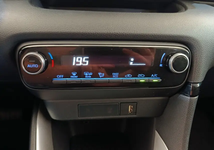 Gros plan sur la commande de climatisation digitale avec affichage à LED dans une Toyota Yaris Hybride 116h gris clair.