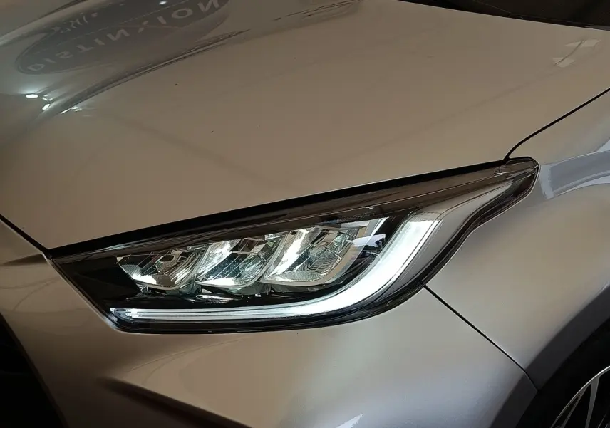Gros plan sur le phare avant droit d'une Toyota Yaris hybride gris clair 2023, soulignant son design LED moderne.