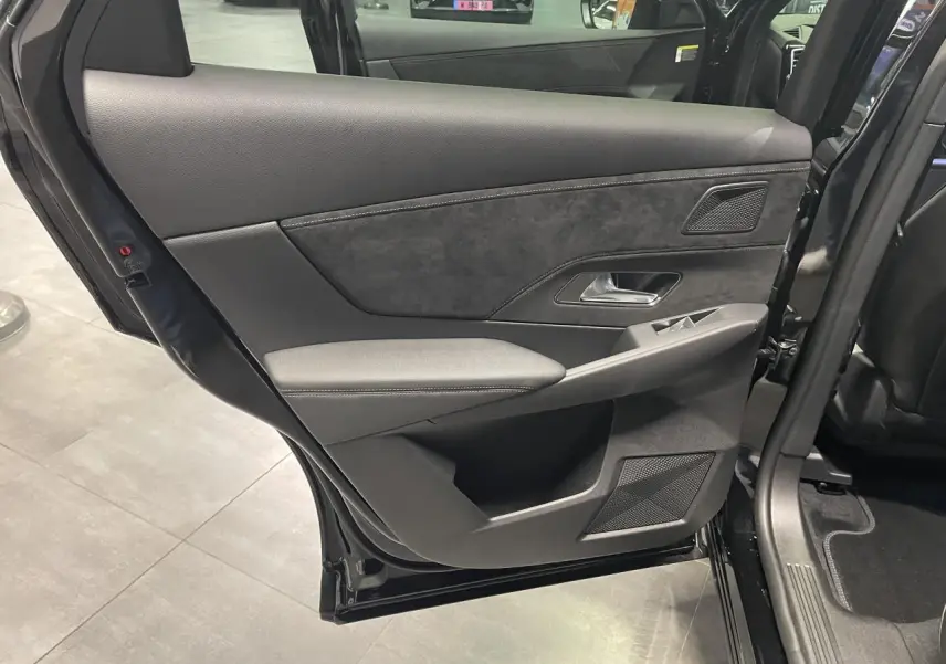 Porte arrière gauche ouverte d'un DS7 Crossback noir métallisé, avec garniture intérieure en Alcantara noir et surpiqûres contrastées.