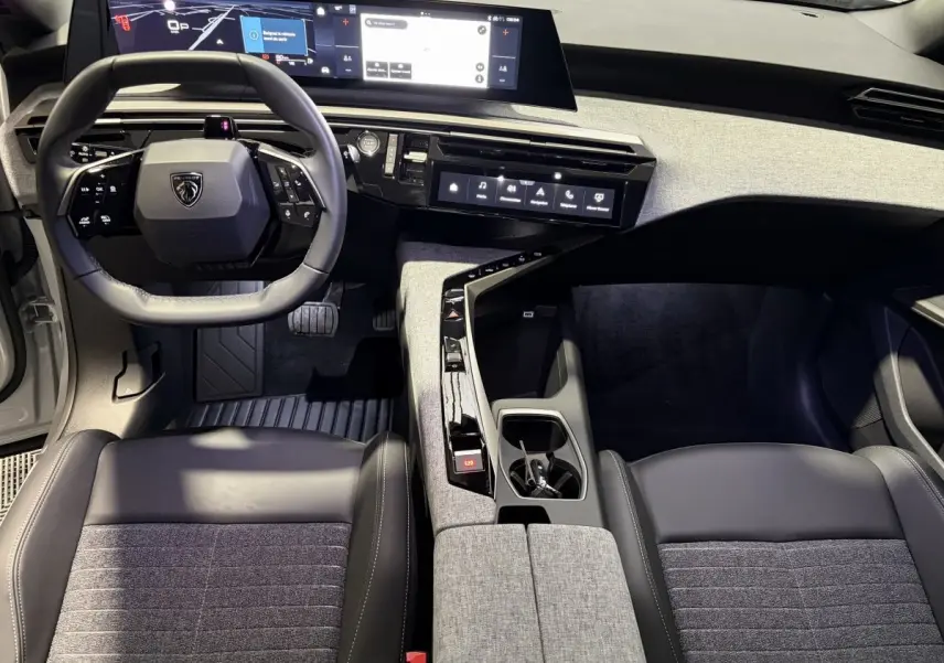 Vue intérieure avant du Peugeot 3008 blanc 2026, mettant en valeur le tableau de bord numérique et la console centrale design.