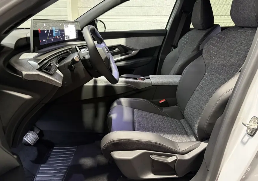 Intérieur côté conducteur du Peugeot 3008 blanc, avec sièges tissu-cuir gris et tableau de bord numérique moderne.