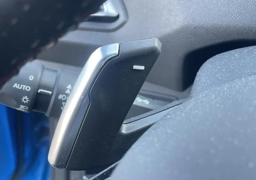 Gros plan sur la palette de changement de vitesse côté droit du volant d'une Peugeot 308 SW bleu Vertigo.