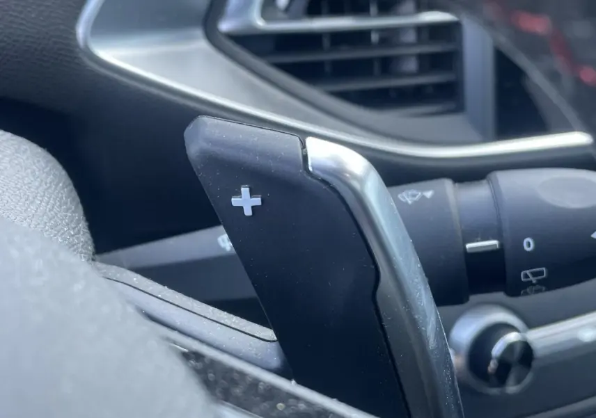 Gros plan sur la palette de changement de vitesse + côté droit du volant d'une Peugeot 308 SW bleu Vertigo.
