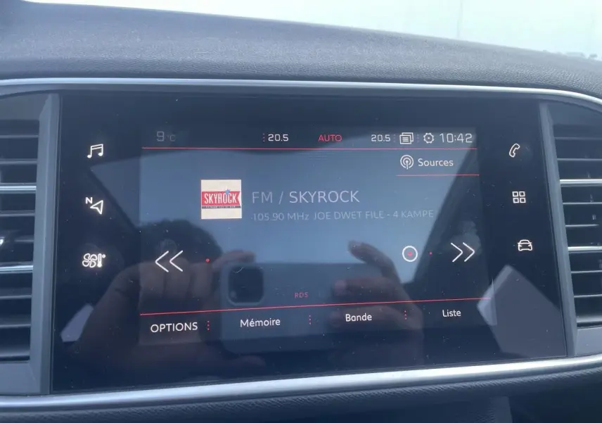 Écran tactile central de la Peugeot 308 SW 2021 affichant la radio FM Skyrock, entouré d'aérations noires.