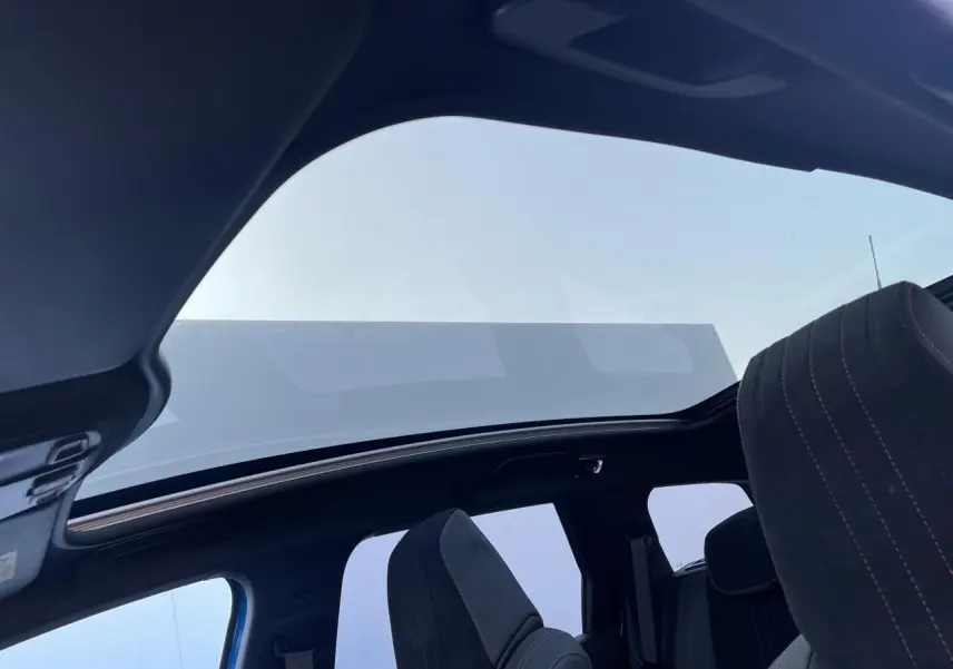 Toit panoramique en verre avec occulteur électrique sur Peugeot 308 SW 2021 bleu Vertigo, vue intérieure arrière côté droit.