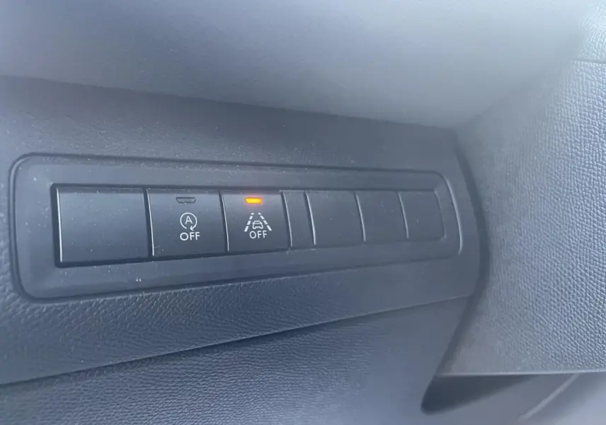 Gros plan sur les boutons de commande noirs du tableau de bord intérieur d'une Peugeot 308 SW bleu Vertigo.