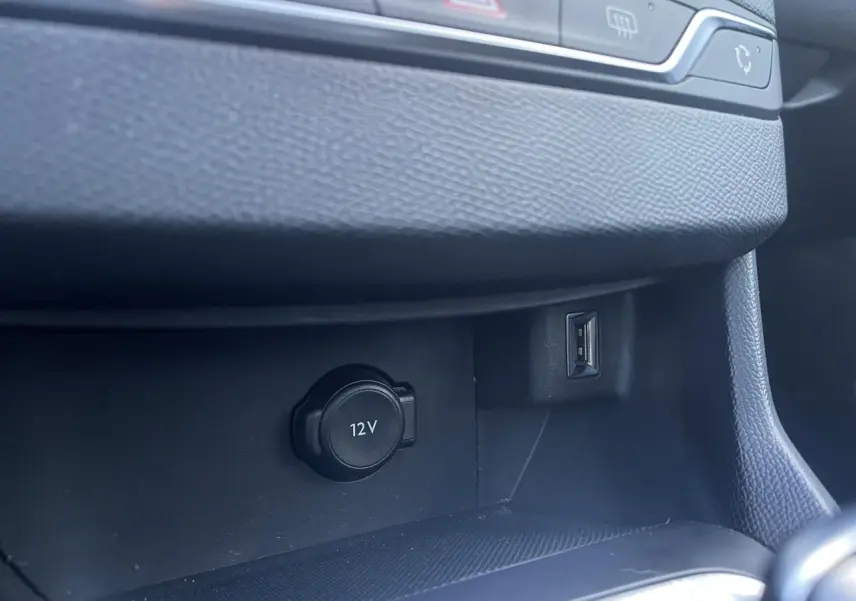 Prise 12V et port USB dans la console centrale noire de la Peugeot 308 II SW Bleu Vertigo, vue intérieure rapprochée.