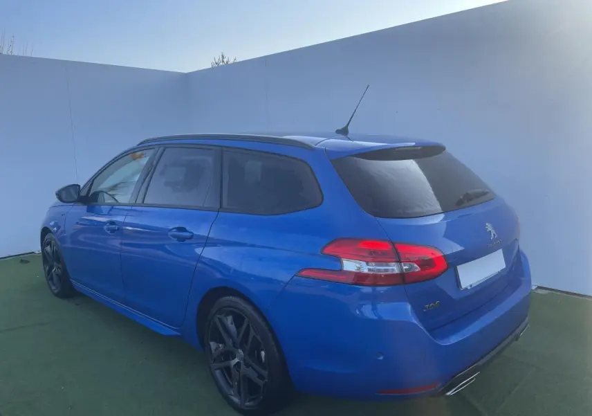Peugeot 308 SW bleu Vertigo vue 3/4 arrière droit avec jantes alliage noires et toit panoramique.