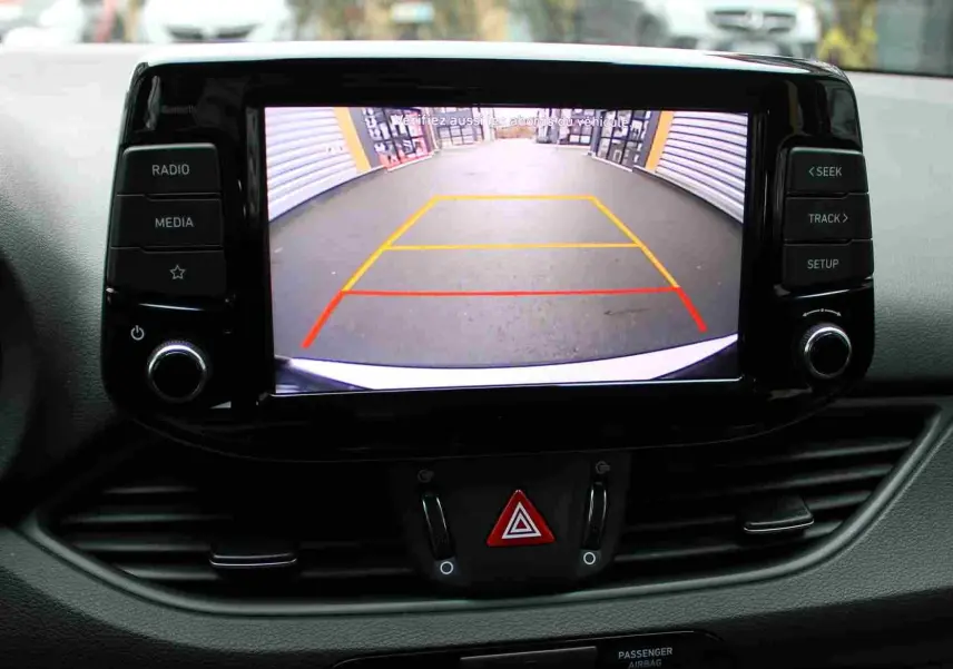 Écran central de la Hyundai i30 SW 2022 montrant la caméra de recul avec lignes de guidage colorées.