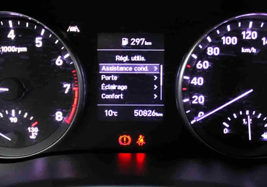 Tableau de bord éclairé de la Hyundai i30 SW blanche, affichant compte-tours, vitesse, température et menu d'assistance conducteur.