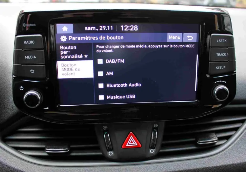 Écran tactile central de la Hyundai i30 SW blanc polaire 2022 affichant les options audio et boutons de commande.