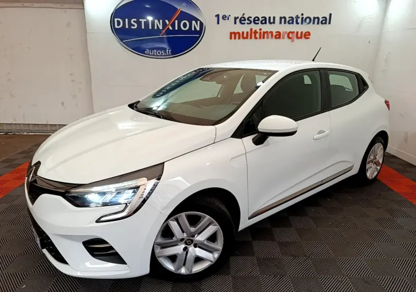 Renault Clio Business TCe 100 blanc vue 3/4 avant droit avec phares LED allumés en intérieur showroom.