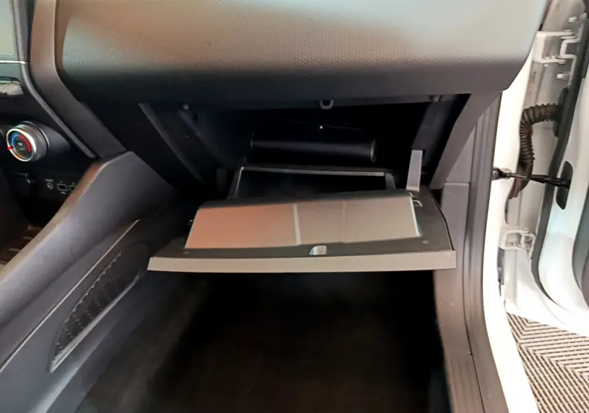 Vue rapprochée de la boîte à gants ouverte côté passager d'une Renault Clio Business blanche de 2020.