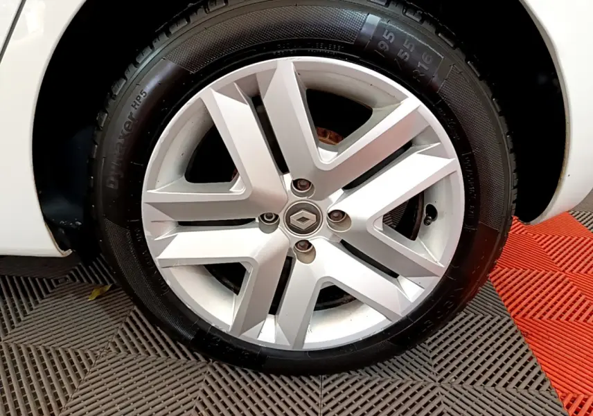 Gros plan sur la roue avant gauche blanche d'une Renault Clio Business TCe 100 avec jante alliage distinctive.